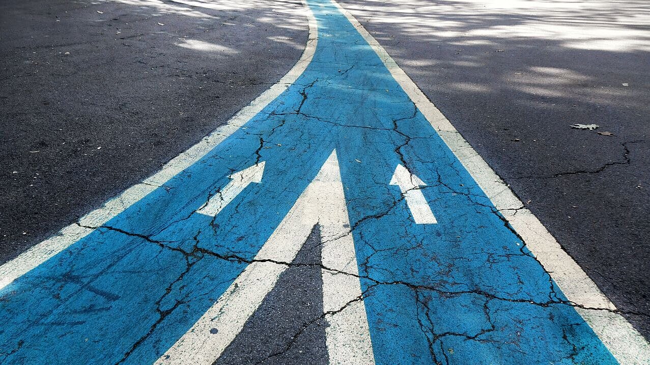 Symbolbild für Transformation: Zwei farbige Wege, die sich zu einem Weg vereinen.
